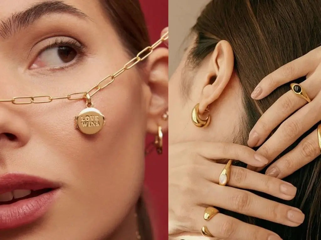 Close-up of a woman wearing gold-tone jewelry, including a necklace with a "LOVE WINS" locket, hoop earrings, and multiple rings.