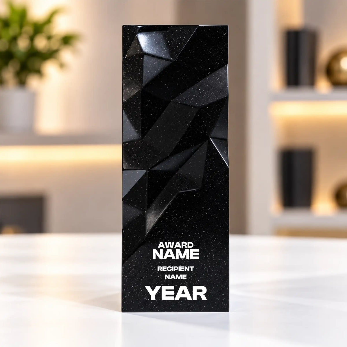 Black geometric faceted crystal award column on a desk