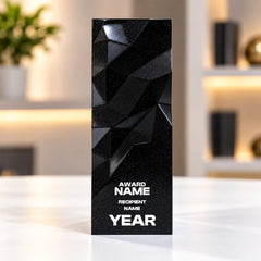 Black geometric faceted crystal award column on a desk