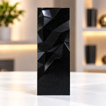 Black geometric faceted crystal award column on a desk