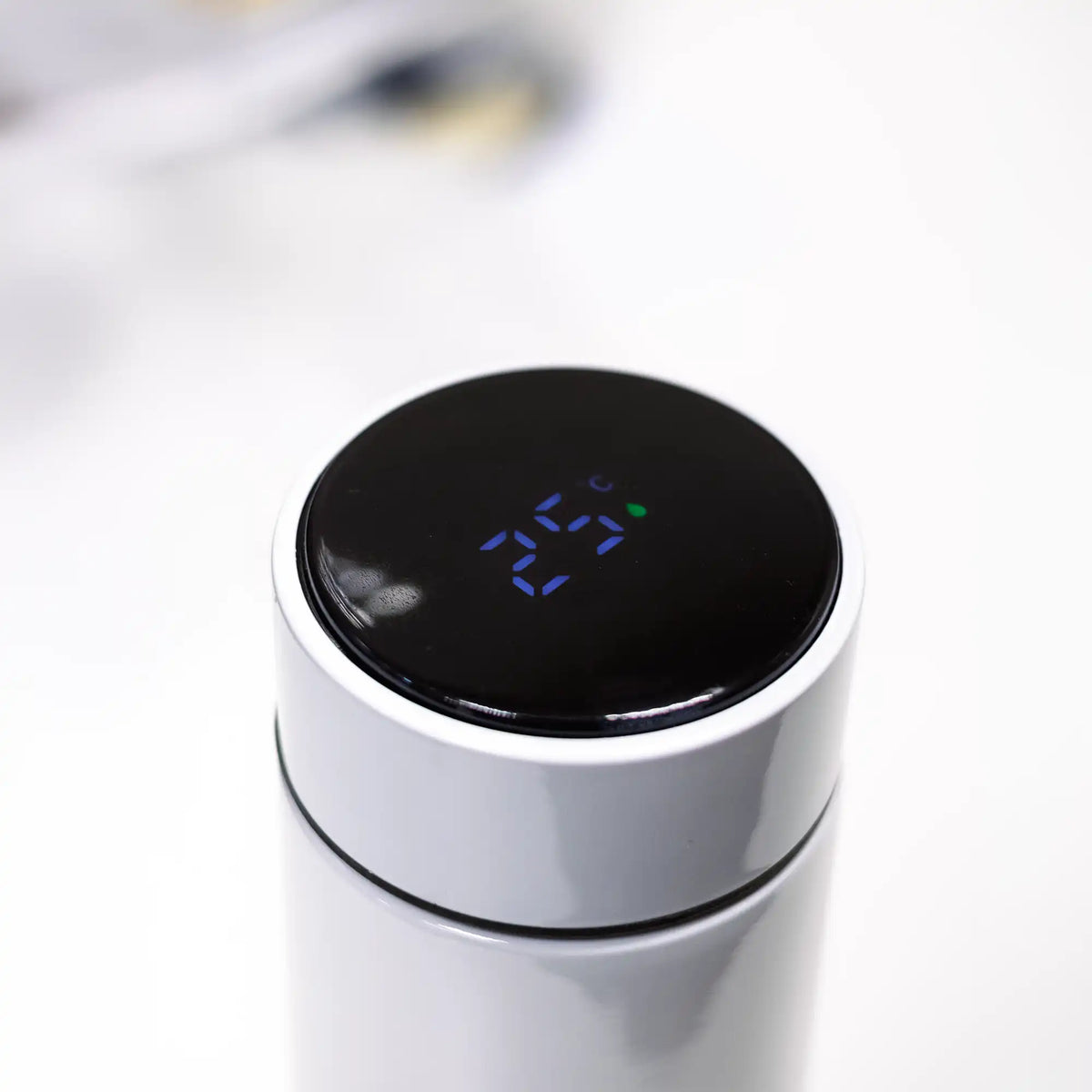 Touch LED temperature display lid close-up on white insulated bottle.