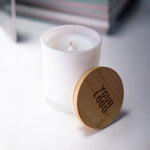 Frosted glass scented candles with bamboo lids in white and black, featuring customizable logo branding.
