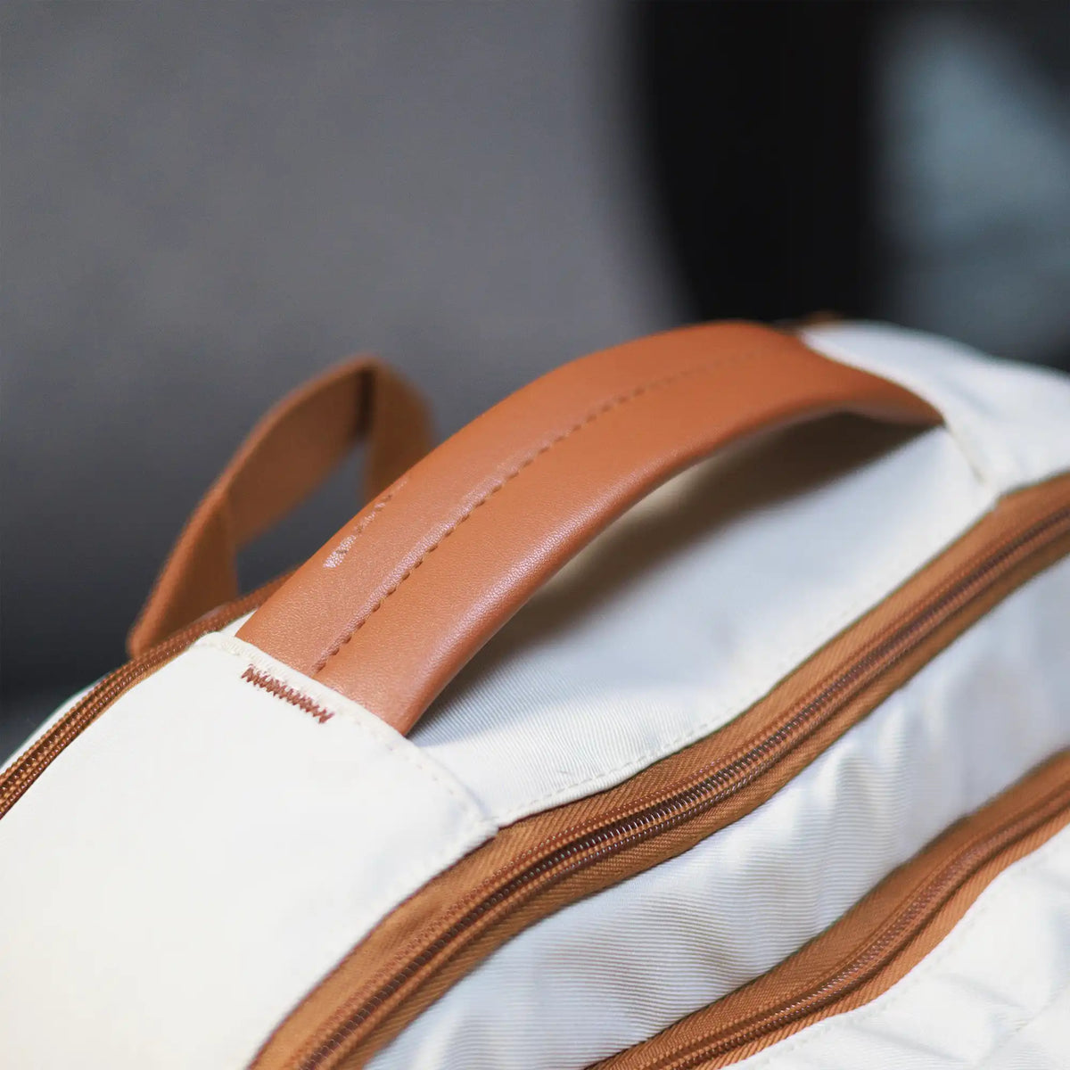 Beige Voxtra travel backpack, front three-quarter view with tan leather trim