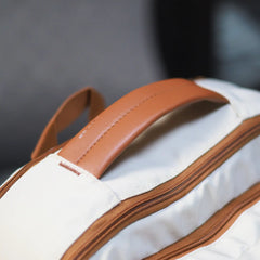 Beige Voxtra travel backpack, front three-quarter view with tan leather trim